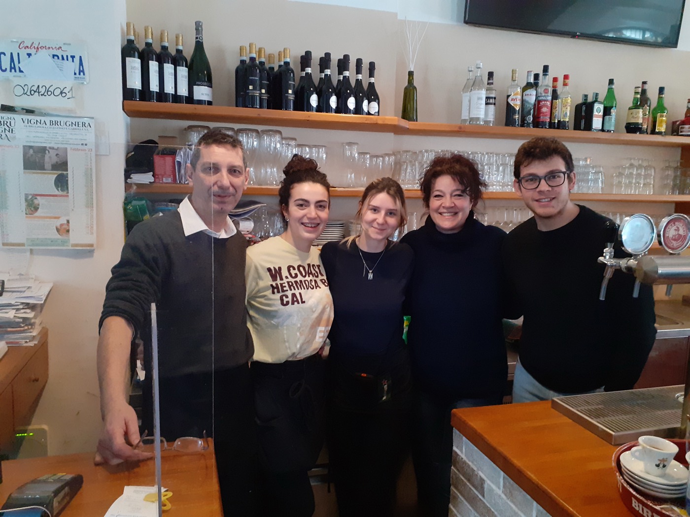 La famiglia della Trattoria California al banco del locale a Niguarda
